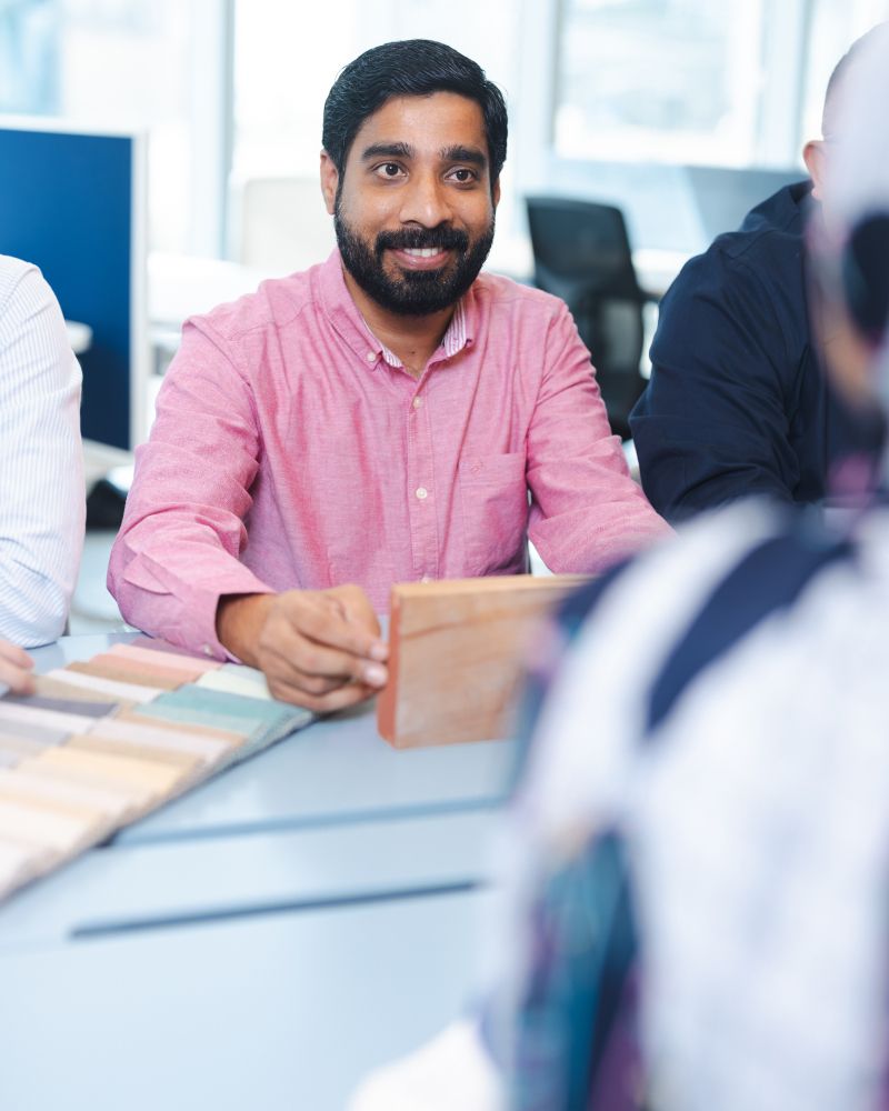 best commercial interior fit out companies abu dhabi person sitting at a desk and smiling