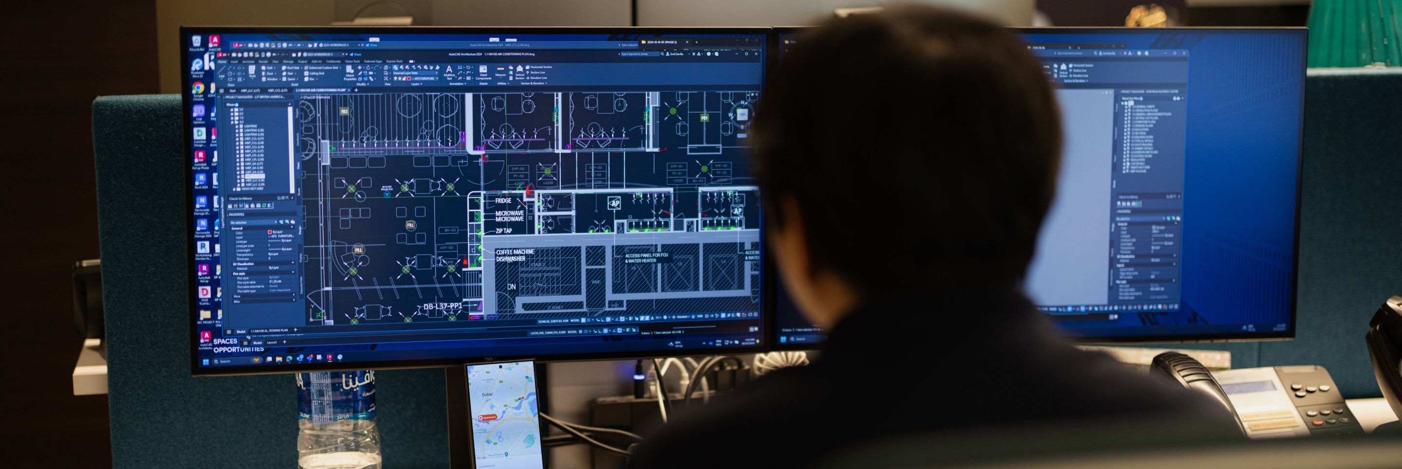 Interior Construction services UAE person working with a wide computer monitor